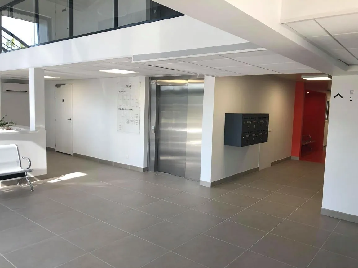 Hall du rez-de-chaussée avec ascenseur et boîtes aux lettres des praticiens
