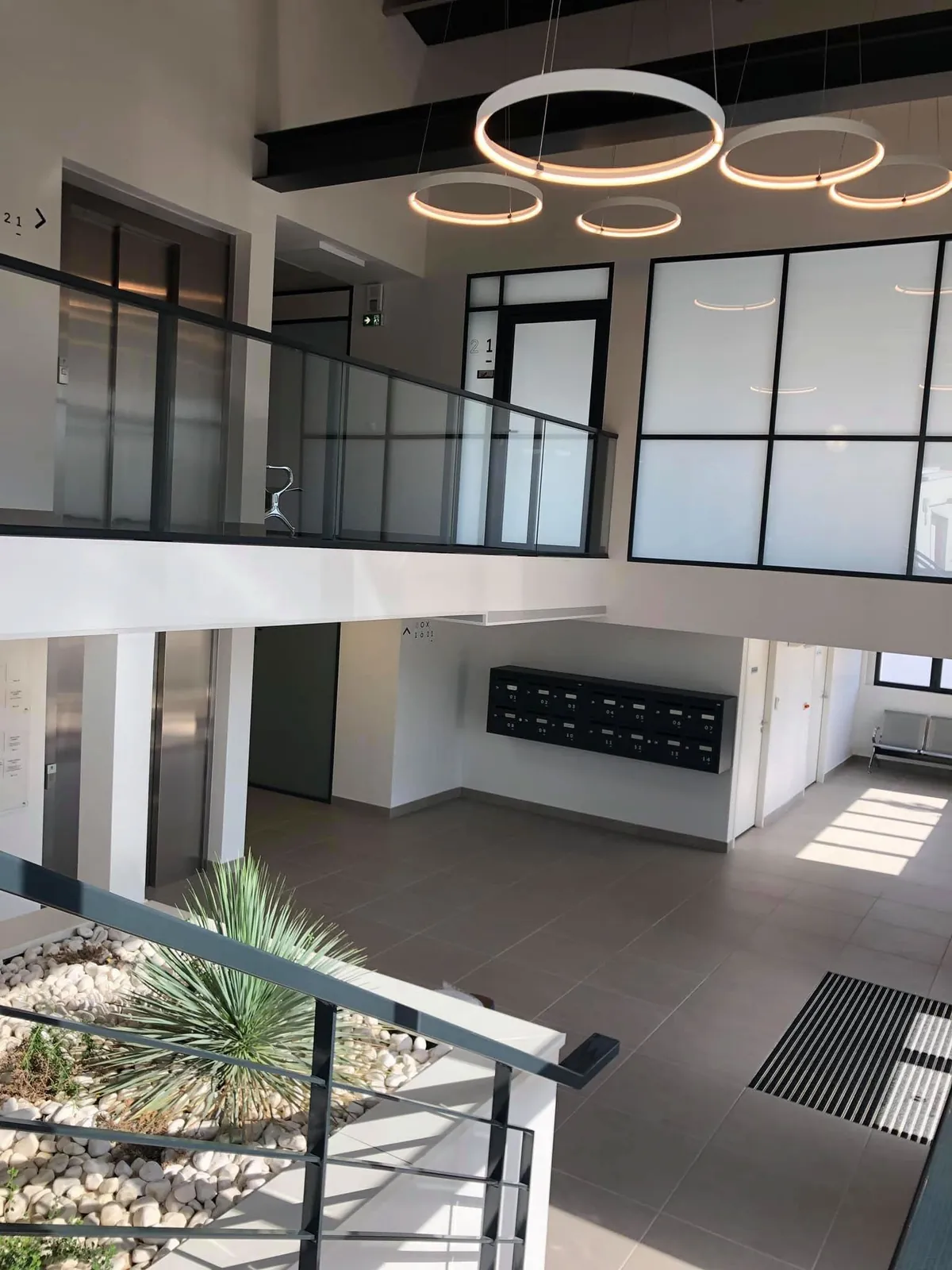 Hall du Pôle Santé de Jacou avec mezzanine, suspensions lumineuses et boîtes aux lettres